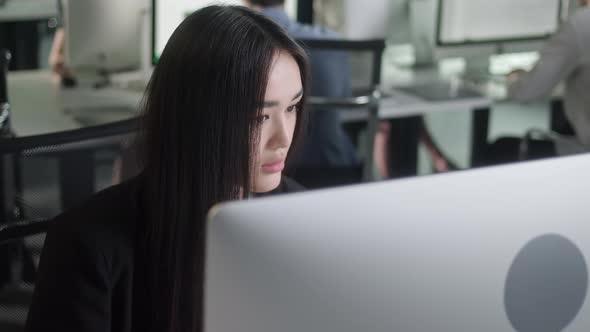 Attractive Young Woman Working on Decktop Computer While Working in Big Open Space Office alt