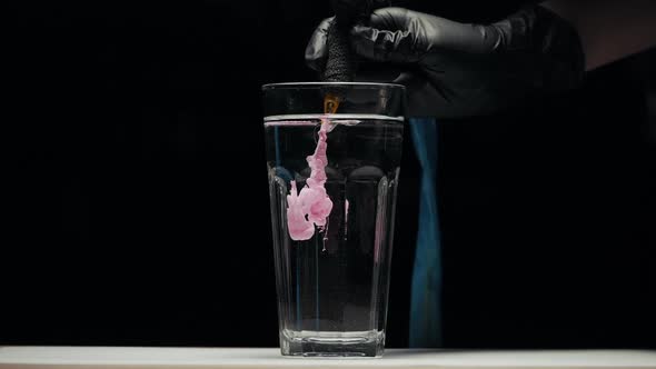 Close-up of Tattoo Machine Cleaning with Needles in Water From Pigment of Paint.