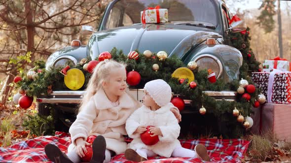 Two Little Girls are Photographed in Christmas Decorations