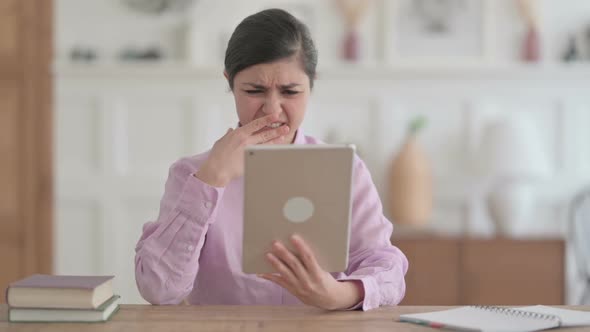 Indian Woman Reacting to Loss on Tablet in Office alt