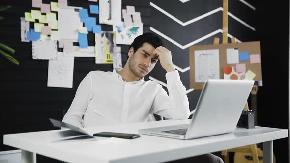 Thoughtful Man Sitting at a Desk and Thinking