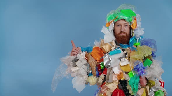 Man wearing garbage costume and showing bon the background by finger