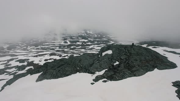 Aerial Over Snow Covered Store Ishaug Mountain With Clouds Rolling Over. Dolly Shot alt