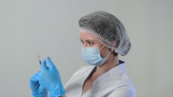 Caucasian Female Doctor or Nurse Holds a Syringe