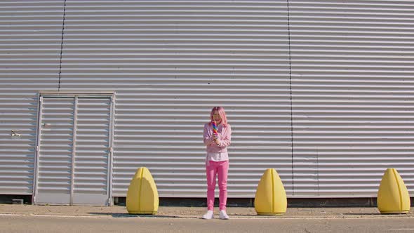 Pink-haired woman shooting confetti in the air, jumping of joy alt