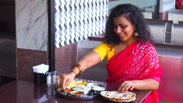 Beautiful Woman Eating Dosa Chutney Naan and Indian Tali in a Restaurant alt