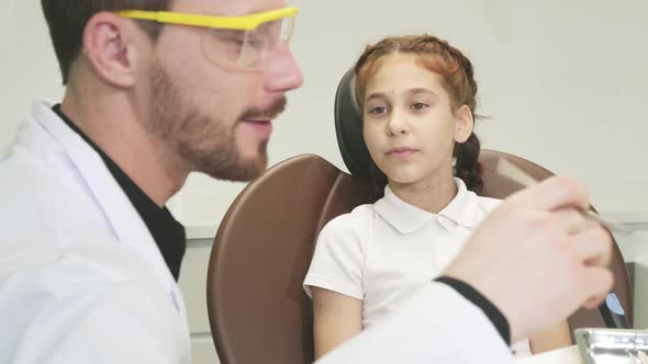 A Kind Doctor Examines the Teeth of a Little Girl