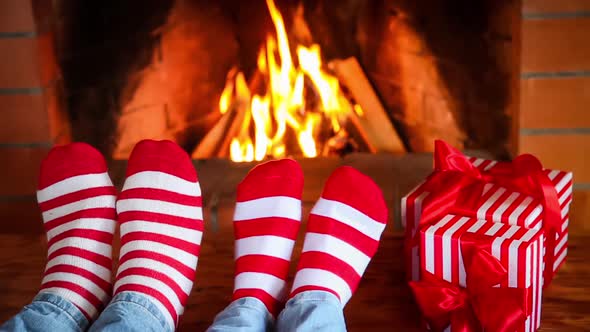 Couple in Christmas Socks Near Fireplace
