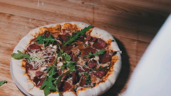 Finished Pizza with Salami and Sausage Chef Sprinkles Hard Cheese. Slow Motion alt