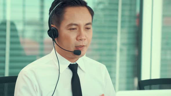 Businessman Wearing Headset Working Actively in Office alt