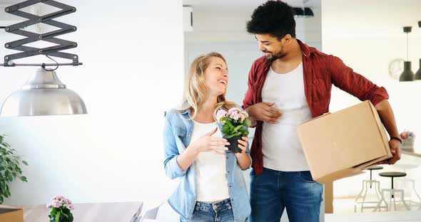 Young Happy Couple Moving in New Home and Unpacking Boxes