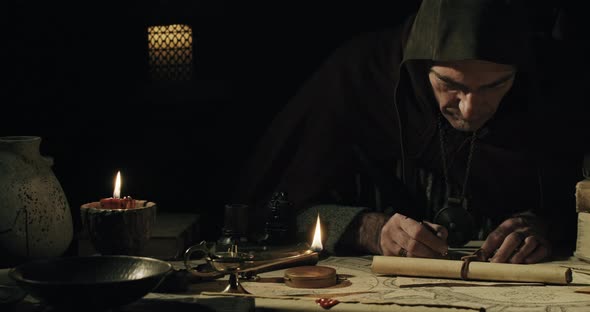 Ancient Scribe Writing with Quill Pen on Old Parchment