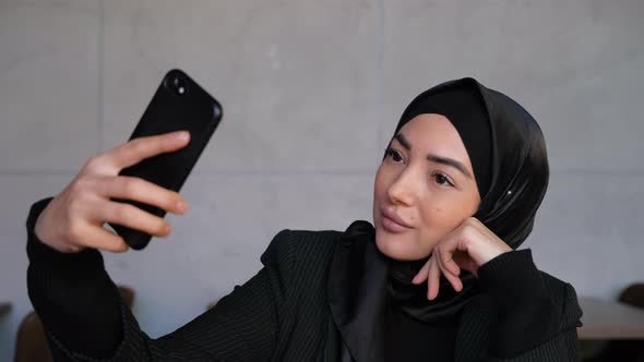Young Muslim Woman in Hijab Taking Selfie on Smartphone
