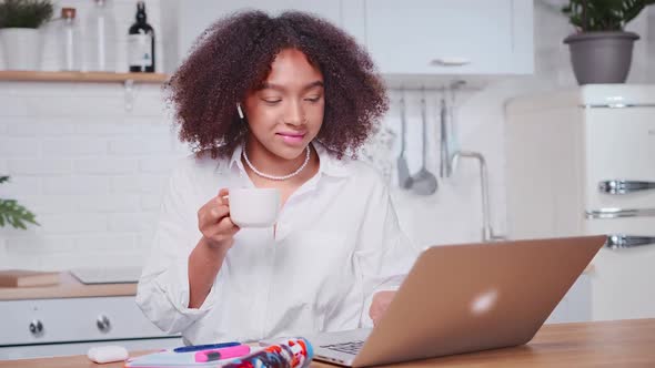 Young African American Woman Freelancer Having Breakfast Sits Front Laptop alt