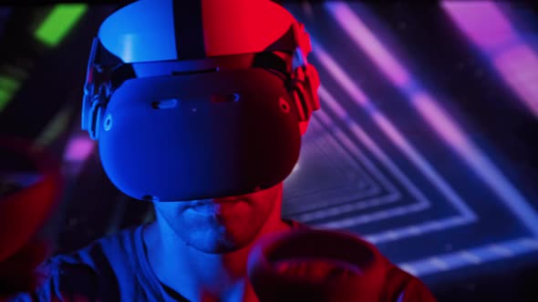 Man in a Virtual Reality Helmet Illuminated in Red and Blue Plays a Game alt