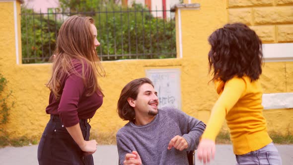 dance, fun - young women dance with their friend with paraplegia alt