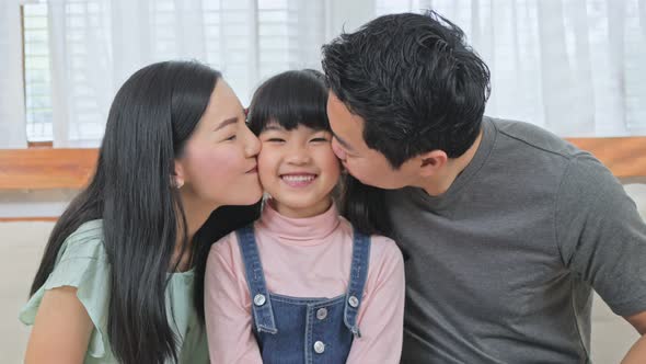 Portrait of Asian happy family parents spend time together with daughter enjoy activity at house. alt