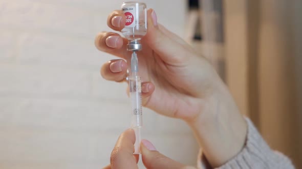 Hands Filling a Syringe with Vaccine