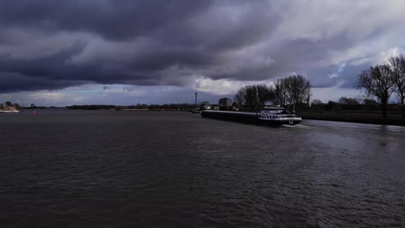 Clouded Sky Over Quiet Oude Maas River With Ship Traveling Near Puttershoek, Netherlands. - Wide Sho alt