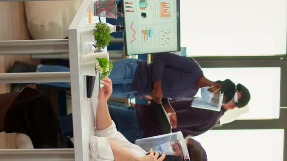 Vertical Video Freelancer with Mask Talking on Mobile Phone in Fron of Computer alt