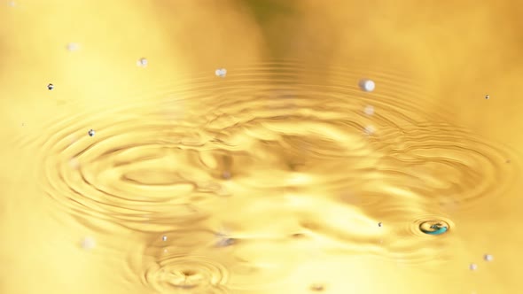Super Slow Motion Detail Shot of Water Drop on Golden Luxury Background at 1000 Fps alt