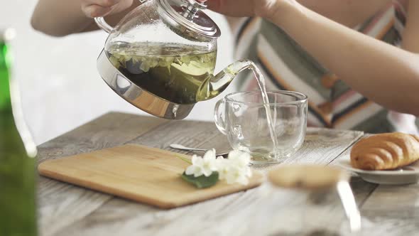 Young Lady Without Face Is Enjoying Hot Drink In The Morning Using Teapot, Cup. Herbal Green Tea alt