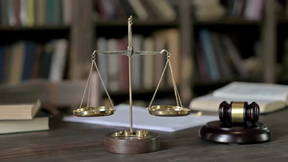Close Up Shoot of Gavel and Gold Brass Balance Scale on Judge Table alt