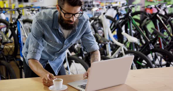 Mechanic using laptop in workshop alt