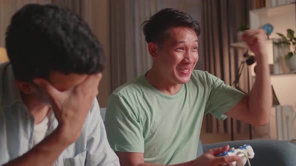 Friends Playing Video Games At Home. Male Happy And Another Man Feeling Disappointed alt