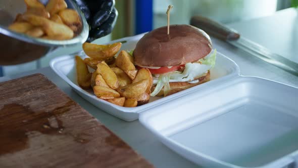 Takeaway Food, a Hot Juicy Burger with Fried Potatoes in a Package for Delivering Food From a Cafe alt