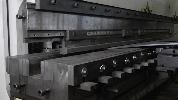 A Machine is Bending a Thick Metal Sheet