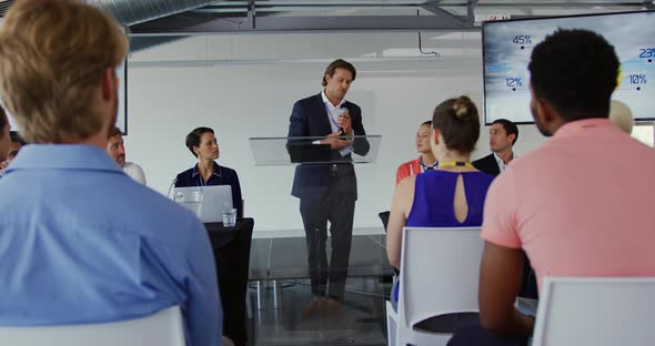 Male speaker addressing the audience at a business conference alt