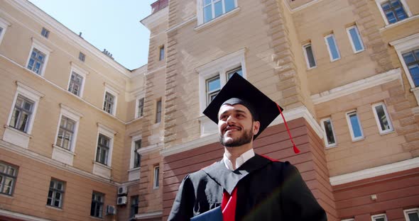 Happy Graduate Student Walking Near College or University. alt