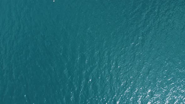 Aerial top down view from high altitude of blue azure turquoise sea water texture. 