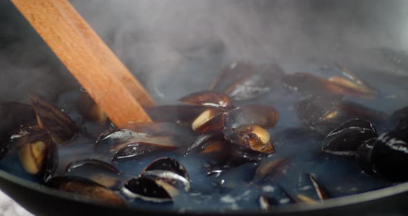 The Mussels Are Stirred in Boiling Water in a Saucepan.  alt