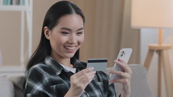 Smiling Asian Ethnic Woman Customer User Holding Bank Credit Card with Virtual Money Typing alt