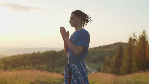 Peaceful Handsome Arab Man Meditating in Prayer Yoga Pose on Mountain Top at Daybreak alt