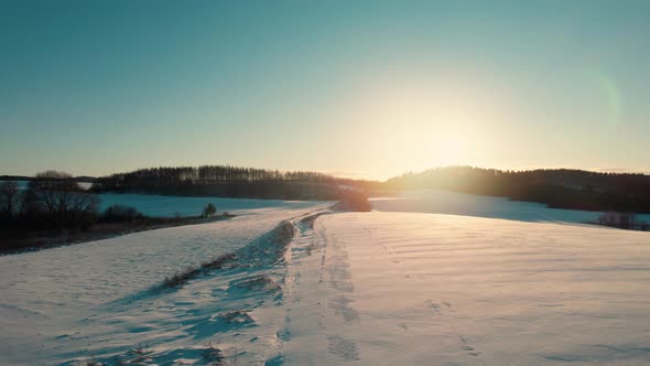 Aerial Drone View of a Fields Covered with Winter Snow during Sunset