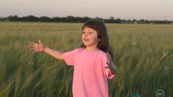 Happy child playing with soap bubbles. alt