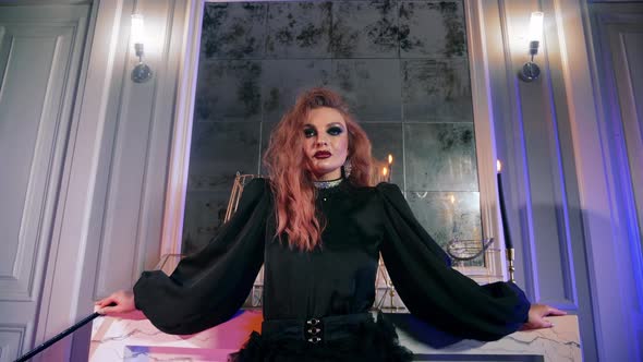 Red Hair Witch Use Magic Wand Halloween. Woman Gothic Makeup Looking at Camera alt