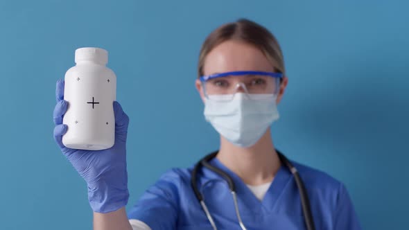 Nurse showing white bottle for pills with tracking markers. Healthcare concept