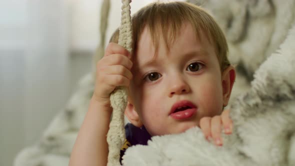 A Kid on a Suspended Swing at Home alt