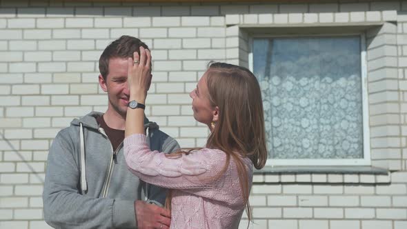 Young Happy Spouses on the Background of Their Home. alt