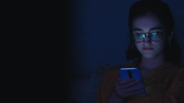Alone Teen Girl Sits in the Evening Near Tv and Uses the Phone Read Some Information