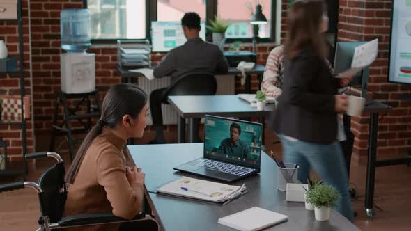 Asian Woman in Wheelchair Meeting with Man on Videocall alt