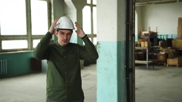 An Engineer Puts a Safety Helmet on His Head on Site