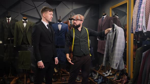 Mature Tailor Helps the Client Choose a Classic Three-piece Suit in an Atelier. Creative Adult alt