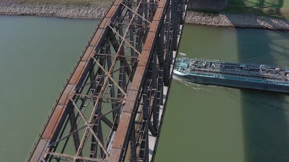 Bulk Carrier Cargo Ship Passing Under An Old Iron Bridge alt