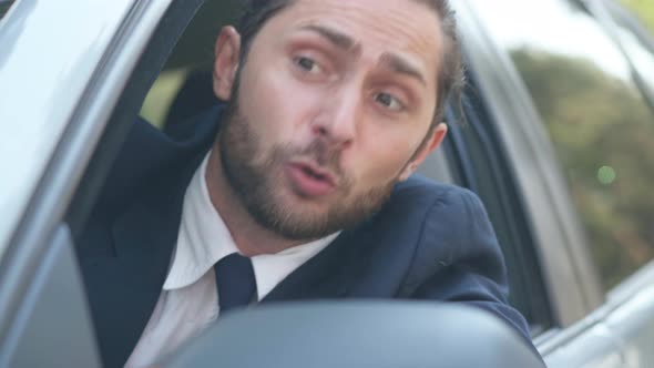 Closeup Angry Male Young Driver Leaning Out Car Window Shouting Gesturing Looking Away alt
