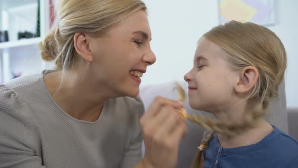 Cheerful Mom Playing Daughters Hair and Touching Nose, Having Fun Together, Rest